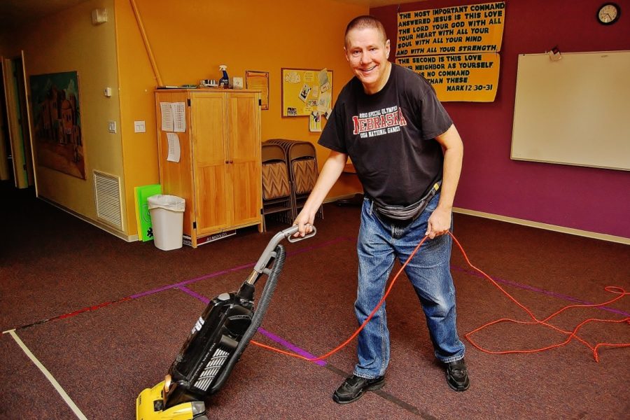 Man doing janitorial work using vacuum cleaner