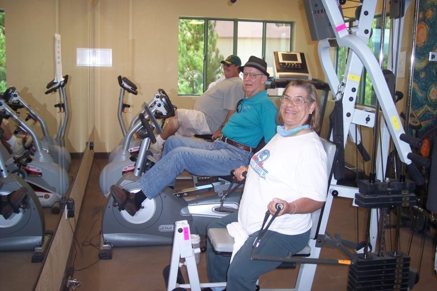 3 adults using exercise machines inside fitness center