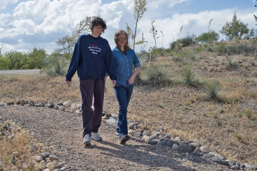 Two people walking together along groomed dirt trail