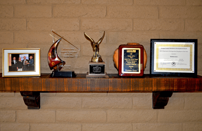 Recent awards received by Rainbow Acres on display shelf