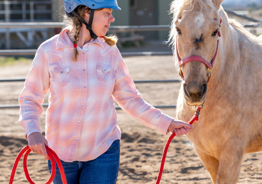 Kelly leads a horse near the barn at Rainbow Acres in the Hands on horses class.