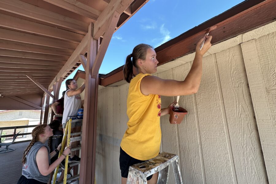 A mission team volunteering at Rainbow Acres, helping to repaint the buildings