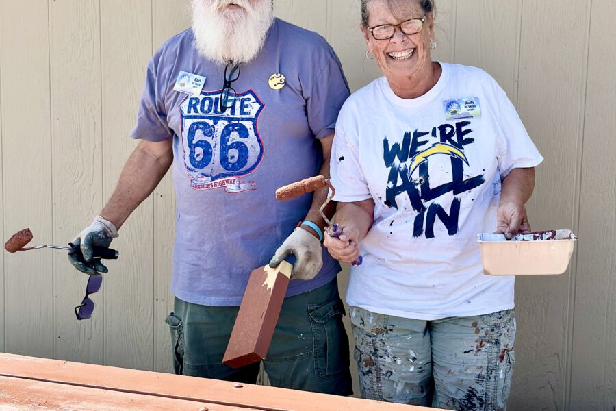 A mission team volunteering at Rainbow Acres, helping to paint picnic tables